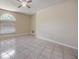 A bright bedroom with tile floors, a ceiling fan, and a large window at 3501 Country Creek Ln, Valrico, FL 33596