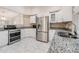 Updated kitchen boasts stainless steel appliances, granite counters, tile floors and bright white cabinetry at 3501 Country Creek Ln, Valrico, FL 33596