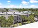 Aerial view of an apartment building with palm trees and lush landscaping at 8693 Bardmoor Blvd # 308B, Seminole, FL 33777