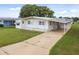 Mobile home with carport and well-maintained lawn at 5353 Comanche St, Zephyrhills, FL 33542