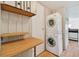 Stackable washer and dryer in a well-lit laundry room with additional storage at 5353 Comanche St, Zephyrhills, FL 33542