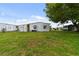 Large grassy backyard with mature trees and mobile home at 5353 Comanche St, Zephyrhills, FL 33542