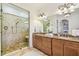 Bathroom with a glass enclosed shower, granite countertops, double sinks, and decorative lighting at 4108 W San Luis St, Tampa, FL 33629