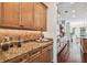 Butler's pantry with granite countertops, tiled backsplash, custom wood cabinets, and stainless steel appliances at 4108 W San Luis St, Tampa, FL 33629