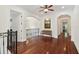 Hallway with hardwood floors, arched doorways, wrought iron railing, and recessed art niche at 4108 W San Luis St, Tampa, FL 33629