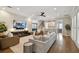 Spacious living room with hardwood floors, comfortable seating, and a large TV at 5013 W Leona St, Tampa, FL 33629