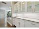 White butler's pantry with glass-front cabinets and marble countertops at 5013 W Leona St, Tampa, FL 33629
