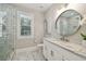 Elegant bathroom with marble flooring, walk-in shower, and white cabinets at 5013 W Leona St, Tampa, FL 33629