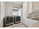 Laundry room with modern washer and dryer, white cabinets, and a quartz countertop at 5013 W Leona St, Tampa, FL 33629