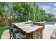 Outdoor kitchen with granite countertops, built-in grill, and bar seating at 5013 W Leona St, Tampa, FL 33629