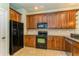 Modern kitchen featuring black appliances and wood cabinets at 10426 La Mirage Ct, Tampa, FL 33615