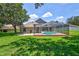 Spacious backyard with lush lawn and screened pool at 805 Woodcarver Ln, Brandon, FL 33510