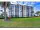 Multi-story building with lush green lawn and palm trees at 2616 Cove Cay Dr # 506, Clearwater, FL 33760