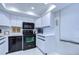 Modern kitchen with white cabinets, black appliances, and tiled floor at 2616 Cove Cay Dr # 506, Clearwater, FL 33760