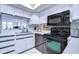 Condo kitchen with white cabinets, black appliances and mirror at 2616 Cove Cay Dr # 506, Clearwater, FL 33760