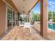 Covered patio with comfortable seating and adjacent pool at 21631 Cormorant Cove Dr, Land O Lakes, FL 34637