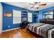 Blue bedroom with wood floors, built-in shelving, and a comfortable bed at 21631 Cormorant Cove Dr, Land O Lakes, FL 34637