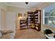 Bright home office features built-in bookshelves, hardwood floors, and ample natural light at 2628 River Bend Dr, Ruskin, FL 33570