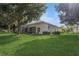 Beautiful home with a screened patio, lush lawn, and mature trees at 10263 Devonshire Lake Dr, Tampa, FL 33647