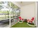 Relaxing screened patio with rocking chairs, overlooking a pond at 10263 Devonshire Lake Dr, Tampa, FL 33647