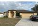 One-story home featuring a beige exterior, brown roof, and attached garage at 4458 Maverick St, North Port, FL 34288