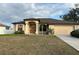 Single-story house with beige exterior, brown roof, and a two-car garage at 4458 Maverick St, North Port, FL 34288