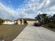 Single-story house with a brown roof, beige walls, and a two-car garage at 4458 Maverick St, North Port, FL 34288