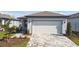 Charming single-story home featuring a two-car garage and a patterned paver driveway at 9413 Ballaster Pointe Loop, Parrish, FL 34219