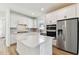 Bright kitchen featuring white cabinetry, stainless steel appliances, and a spacious center island at 9413 Ballaster Pointe Loop, Parrish, FL 34219
