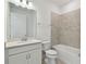 Well-lit bathroom with single sink vanity, white cabinets, and tile surround bathtub at 9421 Ballaster Pointe Loop, Parrish, FL 34219