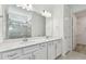 Well-lit bathroom with double sink vanity, white cabinets, and a glass-enclosed shower at 9421 Ballaster Pointe Loop, Parrish, FL 34219
