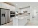 Modern white kitchen features stainless steel appliances, a kitchen island, and tile backsplash at 9421 Ballaster Pointe Loop, Parrish, FL 34219