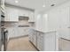 Bright kitchen boasts white cabinetry, stainless steel appliances, gray backsplash, and a center island with a white countertop at 9421 Ballaster Pointe Loop, Parrish, FL 34219