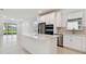 Open kitchen features white cabinets, stainless appliances, center island and seamless flow to living area at 9421 Ballaster Pointe Loop, Parrish, FL 34219