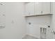 Functional laundry room with upper cabinets and hookups for washer and dryer at 9421 Ballaster Pointe Loop, Parrish, FL 34219
