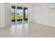 Living area features tile flooring, neutral paint, and glass doors providing natural light and backyard access at 9421 Ballaster Pointe Loop, Parrish, FL 34219