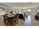 Dining area with a wooden table and chairs, adjacent to the living room and sliding glass doors at 16321 Treasure Point Dr, Wimauma, FL 33598