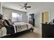 Spacious bedroom with a large bed, dresser, and window coverings at 16321 Treasure Point Dr, Wimauma, FL 33598