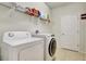 Functional laundry room with washer, dryer, and shelving at 16321 Treasure Point Dr, Wimauma, FL 33598