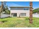 Spacious backyard features a well-maintained lawn, modern home exterior, and a white privacy fence at 2509 N Glenwood Dr, Tampa, FL 33602