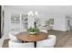 Dining area featuring a wooden table, white chairs, modern light fixture, and lots of natural light at 2509 N Glenwood Dr, Tampa, FL 33602