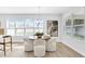 Bright dining area features modern chandelier, large windows, and stylish, comfortable white chairs at 2509 N Glenwood Dr, Tampa, FL 33602