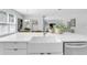 Bright kitchen showcasing an island with a white farmhouse sink, quartz countertops and stainless steel dishwasher at 2509 N Glenwood Dr, Tampa, FL 33602