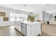 Bright modern kitchen featuring a kitchen island, farmhouse sink, dishwasher, and wood floors at 2509 N Glenwood Dr, Tampa, FL 33602