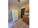 Functional kitchen featuring light wood cabinets, a white refrigerator, and a secure door with a metal gate at 4407 N 41St St, Tampa, FL 33610