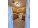 Compact kitchen equipped with light wood cabinets and white appliances, complemented by tiled flooring at 4407 N 41St St, Tampa, FL 33610