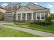 Two-story house with gray siding, a three-car garage, and a well-maintained lawn at 14292 Swiss Bridge Dr, Riverview, FL 33579