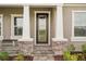 Elegant front door with glass panels and a stone-accented entryway at 14292 Swiss Bridge Dr, Riverview, FL 33579
