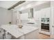 Bright kitchen featuring white cabinets, quartz countertops, and a stainless steel range hood at 14292 Swiss Bridge Dr, Riverview, FL 33579