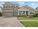 Two-story house with gray siding, three car garage and nicely landscaped yard at 14292 Swiss Bridge Dr, Riverview, FL 33579